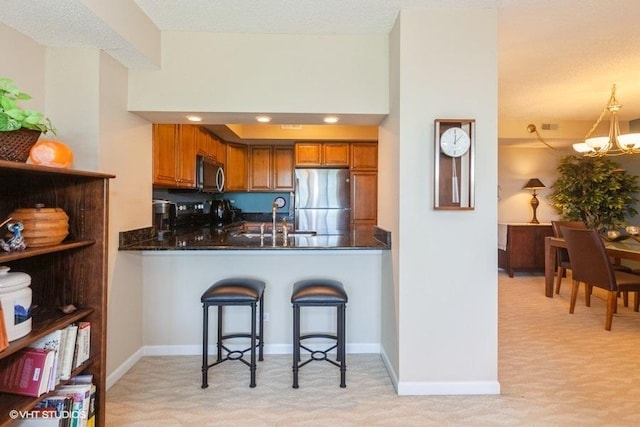 511 Aurora Ave Unit 405, Naperville, IL 60540 - kitchen featuring stainless steel appliances, brown cabinetry, light colored carpet, a chandelier, and a peninsula
