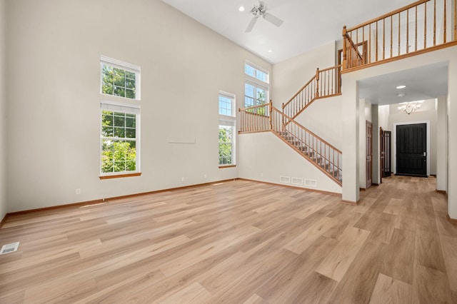 619 Northgate Dr, Sycamore, IL 60178 - unfurnished living room featuring stairs, healthy amount of natural light, a towering ceiling, light wood-type flooring, and a ceiling fan