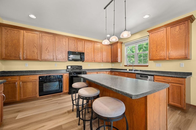 619 Northgate Dr, Sycamore, IL 60178 - kitchen featuring black appliances, a breakfast bar area, brown cabinets, light wood-type flooring, and dark countertops