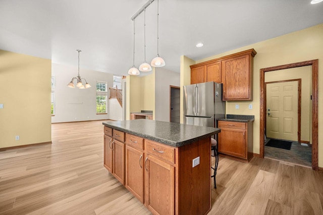 619 Northgate Dr, Sycamore, IL 60178 - kitchen with freestanding refrigerator, dark countertops, a chandelier, a kitchen island, and light wood-style floors