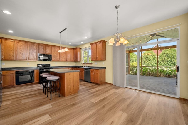 619 Northgate Dr, Sycamore, IL 60178 - kitchen with black appliances, dark countertops, brown cabinetry, a center island, and recessed lighting