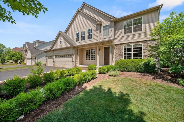 619 Northgate Dr, Sycamore, IL 60178 - view of front of home featuring stone siding, driveway, a front lawn, and an attached garage