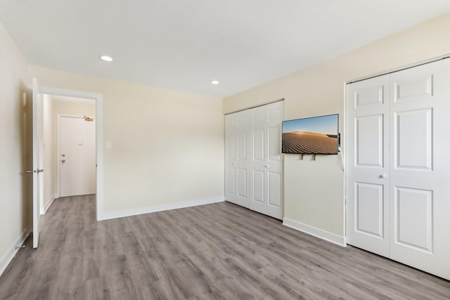 9250 Noel Ave Unit 205E, Des Plaines, IL 60016 - unfurnished bedroom featuring multiple closets, wood finished floors, and recessed lighting
