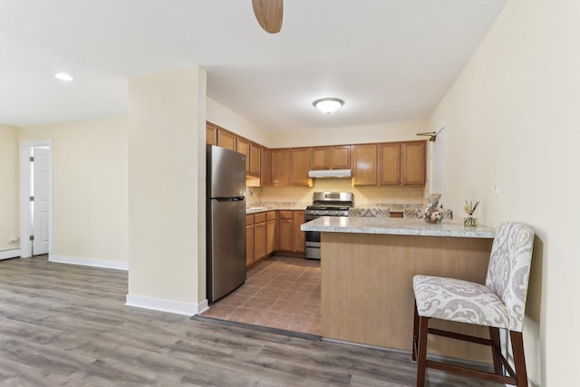 9250 Noel Ave Unit 205E, Des Plaines, IL 60016 - kitchen with stainless steel appliances, a peninsula, light countertops, tasteful backsplash, and under cabinet range hood