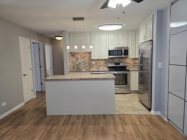 836 E Old Willow Rd Unit 109, Prospect Heights, IL 60070 - kitchen with appliances with stainless steel finishes, a ceiling fan, white cabinets, tasteful backsplash, and a center island