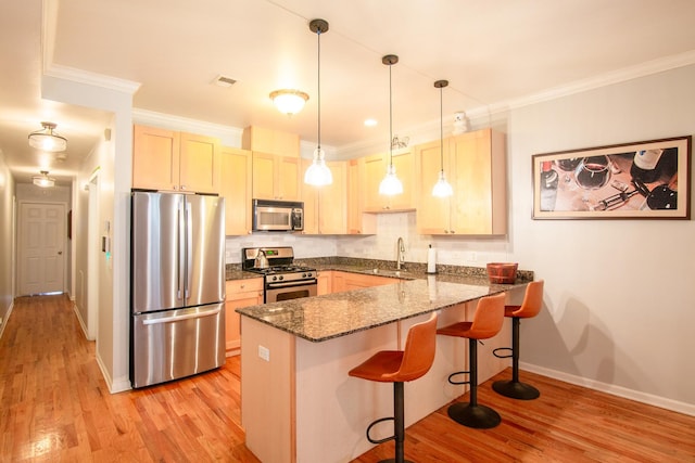 633 E Bowen Ave Unit 1E, Chicago, IL 60653 - kitchen featuring appliances with stainless steel finishes, a peninsula, a breakfast bar, light wood-style flooring, and ornamental molding