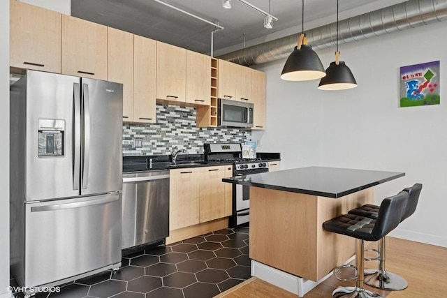 212 E Cullerton St Unit 702, Chicago, IL 60616 - kitchen with appliances with stainless steel finishes, light brown cabinets, dark countertops, a breakfast bar area, and decorative backsplash