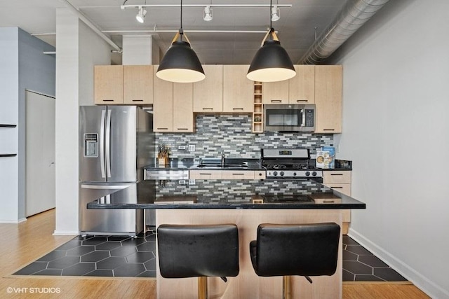 212 E Cullerton St Unit 702, Chicago, IL 60616 - kitchen with appliances with stainless steel finishes, light brown cabinetry, dark countertops, and a breakfast bar area