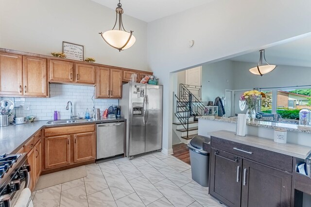 189 Westwood Dr, Park Forest, IL 60466 - kitchen featuring appliances with stainless steel finishes, decorative light fixtures, tasteful backsplash, brown cabinetry, and a towering ceiling