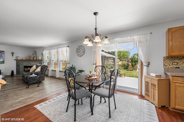 2930 Plumrose Ln, Mchenry, IL 60050 - dining space featuring a chandelier, wood finished floors, and a tiled fireplace