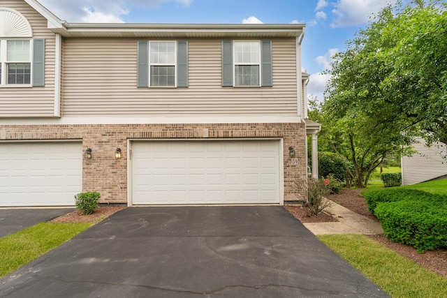 59 Colonial Ct, Streamwood, IL 60107 - view of front of property featuring asphalt driveway, brick siding, and a garage