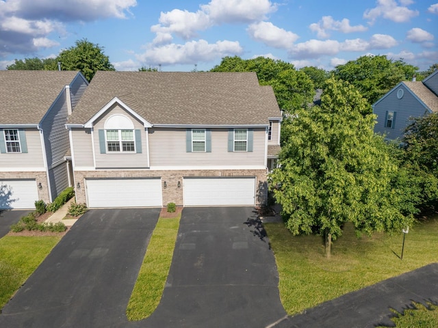 59 Colonial Ct, Streamwood, IL 60107 - view of front facade with asphalt driveway, an attached garage, brick siding, roof with shingles, and a front lawn
