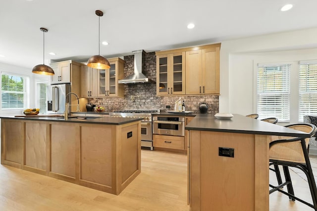9709 S Leavitt St, Chicago, IL 60643 - kitchen featuring appliances with stainless steel finishes, wall chimney range hood, dark countertops, a kitchen bar, and light wood-style floors