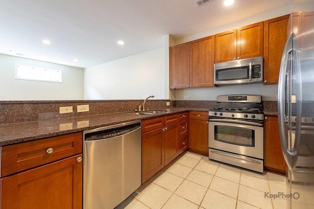 915 S Oak Park Ave Unit 1B, Oak Park, IL 60304 - kitchen with appliances with stainless steel finishes, brown cabinets, dark stone countertops, light tile patterned floors, and recessed lighting