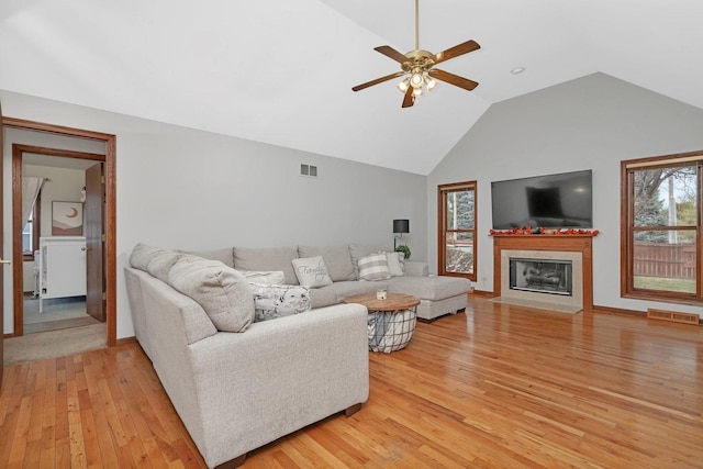 5209 Meadowbrook St, Plainfield, IL 60586 - living area featuring light wood finished floors, plenty of natural light, ceiling fan, a fireplace with flush hearth, and high vaulted ceiling