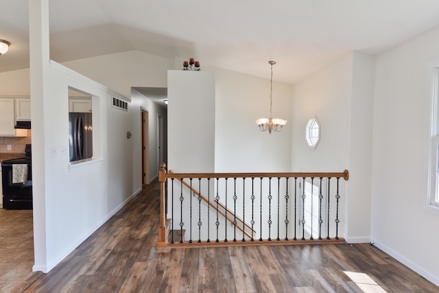 1409 N Nixon Dr, Pontiac, IL 61764 - corridor featuring an upstairs landing, dark wood-style flooring, a chandelier, and lofted ceiling