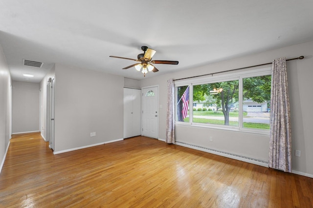 809 S Longview Rd, Monticello, IL 61856 - empty room with a baseboard radiator, light wood-style floors, and ceiling fan