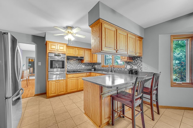 8353 Arrowhead Ln, Orland Park, IL 60462 - kitchen featuring stainless steel appliances, a warming drawer, a peninsula, backsplash, and vaulted ceiling