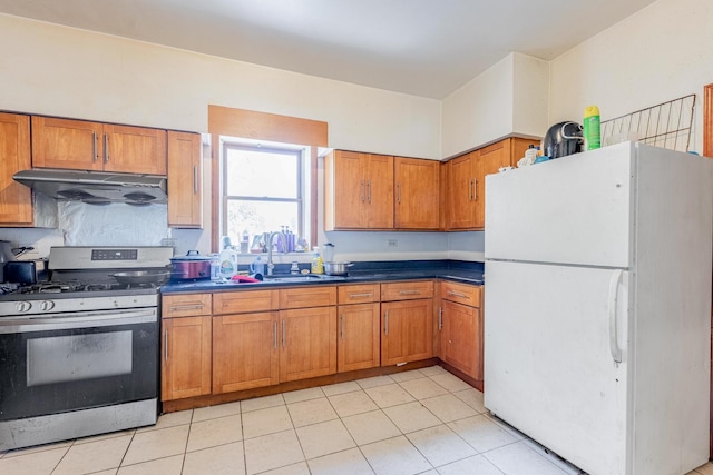 2958 S Lowe Ave, Chicago, IL 60616 - kitchen featuring freestanding refrigerator, gas stove, under cabinet range hood, and brown cabinets