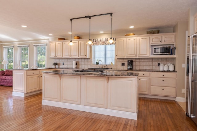 605 Ironwood Cc Dr, Normal, IL 61761 - kitchen featuring appliances with stainless steel finishes, a center island, dark stone counters, backsplash, and recessed lighting