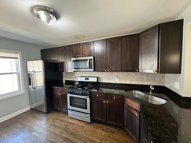 6433 N Damen Ave Unit 3E, Chicago, IL 60645 - kitchen with appliances with stainless steel finishes, dark brown cabinetry, dark wood finished floors, dark stone countertops, and tasteful backsplash