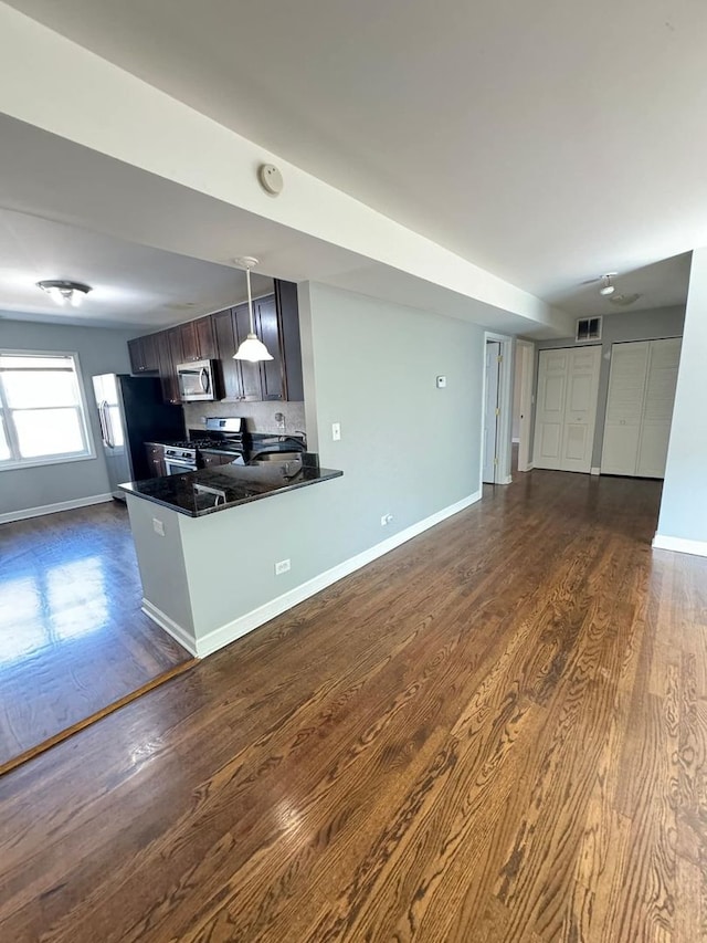 6433 N Damen Ave Unit 3E, Chicago, IL 60645 - kitchen with appliances with stainless steel finishes, open floor plan, dark wood-type flooring, and a peninsula