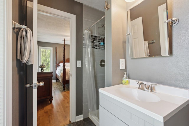 11740 Wagon Ln, Roscoe, IL 61073 - ensuite bathroom featuring a tile shower, wood finished floors, and vanity