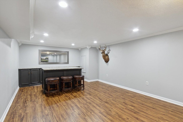 11740 Wagon Ln, Roscoe, IL 61073 - basement with dark wood finished floors, recessed lighting, crown molding, and bar area