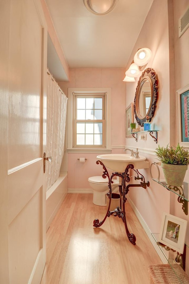 410 W 12th St, Sterling, IL 61081 - bathroom with wood finished floors and shower / bathtub combination with curtain