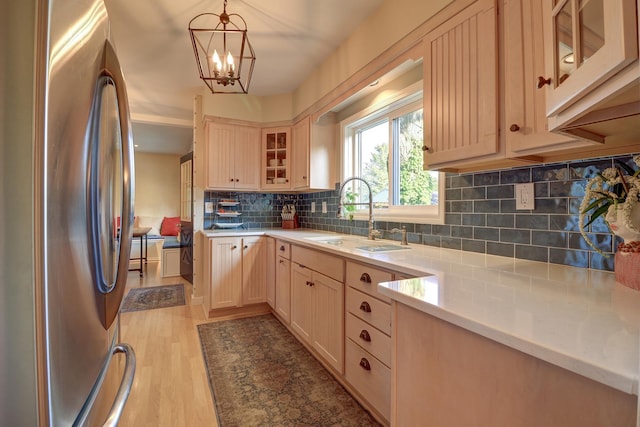 410 W 12th St, Sterling, IL 61081 - kitchen featuring freestanding refrigerator, light brown cabinets, a chandelier, light countertops, and tasteful backsplash