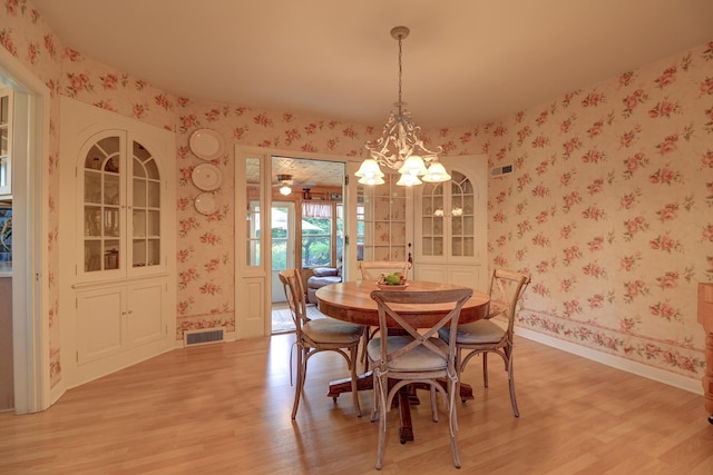 410 W 12th St, Sterling, IL 61081 - dining area with wallpapered walls, light wood-style flooring, and a chandelier