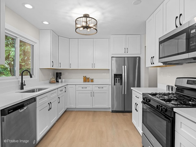 6950 Longmeadow Ln, Hanover Park, IL 60133 - kitchen with appliances with stainless steel finishes, light countertops, light wood finished floors, white cabinets, and a chandelier