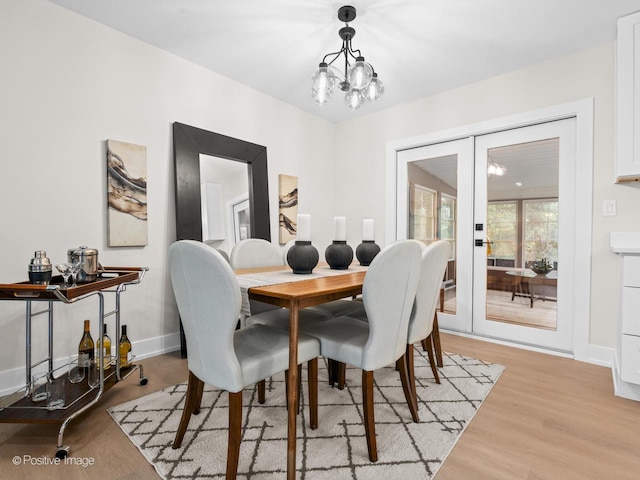 6950 Longmeadow Ln, Hanover Park, IL 60133 - dining room with a chandelier, light wood-style flooring, and french doors