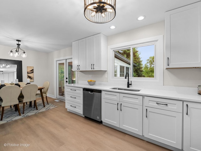 6950 Longmeadow Ln, Hanover Park, IL 60133 - kitchen featuring dishwasher, a chandelier, light wood-style floors, light countertops, and white cabinets