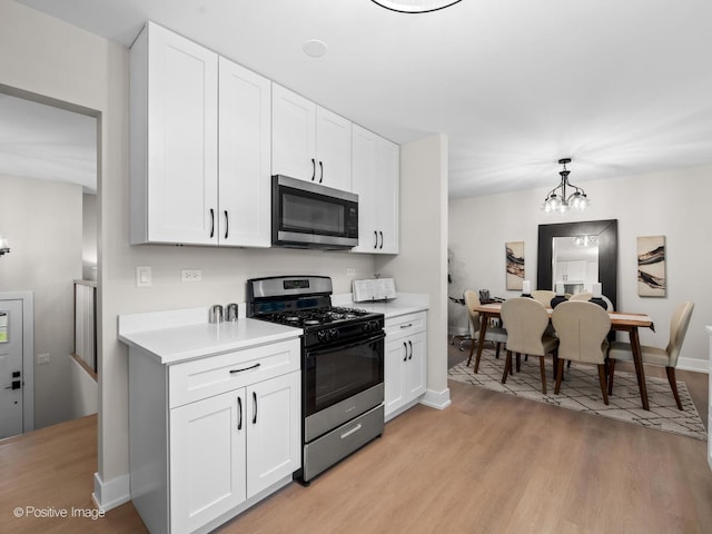 6950 Longmeadow Ln, Hanover Park, IL 60133 - kitchen with stainless steel microwave, gas range, light countertops, and light wood finished floors