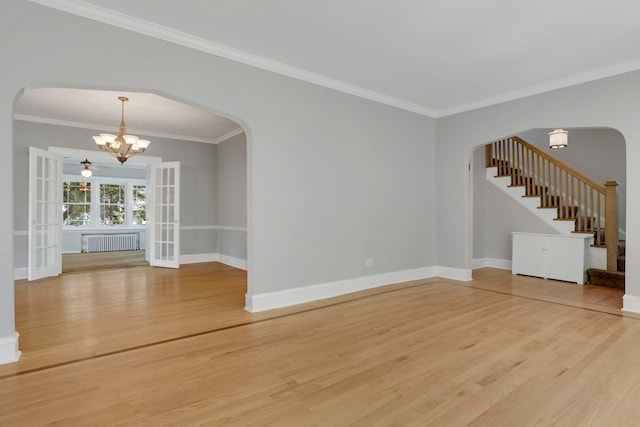 3838 Johnson Ave, Western Springs, IL 60558 - unfurnished living room with radiator heating unit, a chandelier, arched walkways, light wood-type flooring, and ornamental molding