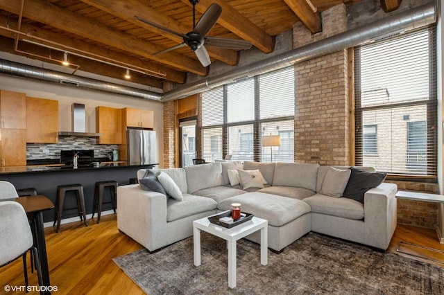 1040 W Adams St Unit 406, Chicago, IL 60607 - living area featuring a wood ceiling with exposed beams, rail lighting, ceiling fan, wood finished floors, and brick wall