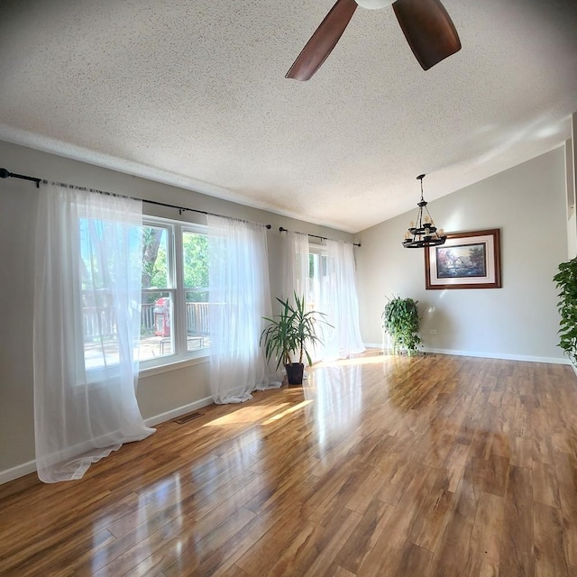 614 Lyon Ct, Buffalo Grove, IL 60089 - unfurnished living room featuring a textured ceiling, wood finished floors, a chandelier, and a ceiling fan