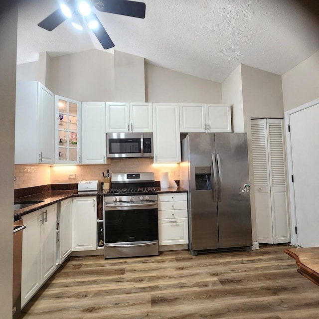 614 Lyon Ct, Buffalo Grove, IL 60089 - kitchen featuring appliances with stainless steel finishes, lofted ceiling, dark countertops, a textured ceiling, and white cabinets