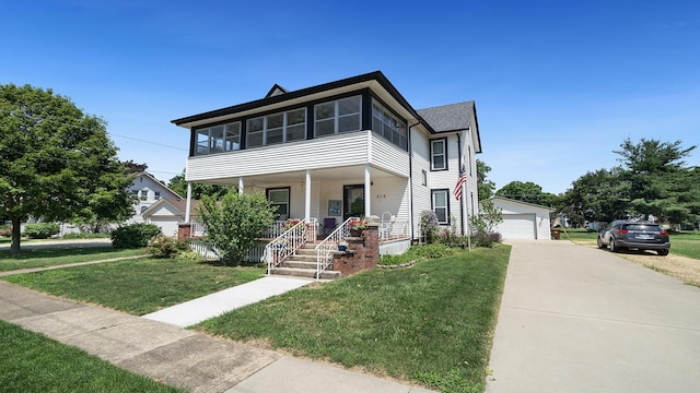 215 E 3rd St, Byron, IL 61010 - view of front of house featuring covered porch, a front yard, a garage, and an outdoor structure