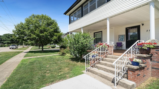 215 E 3rd St, Byron, IL 61010 - doorway to property with covered porch and a lawn