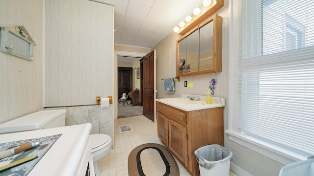 215 E 3rd St, Byron, IL 61010 - bathroom featuring vanity, wallpapered walls, and a wainscoted wall
