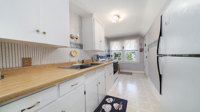 215 E 3rd St, Byron, IL 61010 - kitchen featuring freestanding refrigerator, electric stove, white cabinetry, light countertops, and backsplash