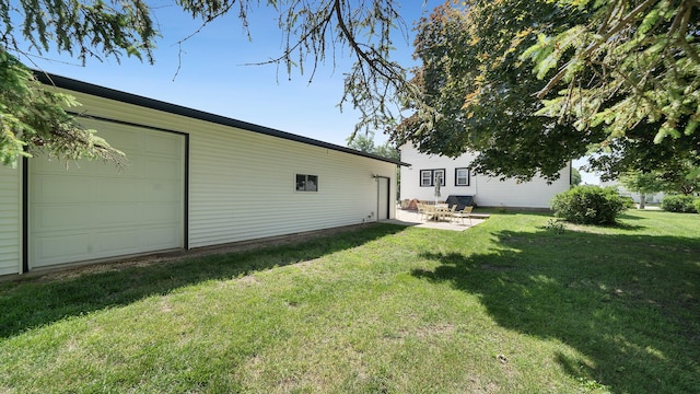 215 E 3rd St, Byron, IL 61010 - view of grassy yard featuring a garage and a patio area