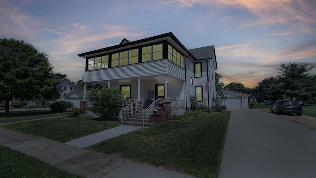 215 E 3rd St, Byron, IL 61010 - contemporary house with a porch, a front yard, a garage, and an outbuilding