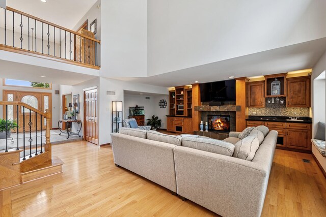 9901 Mission, Palos Park, IL 60464 - living area featuring a towering ceiling, a tile fireplace, light wood-style floors, recessed lighting, and stairs