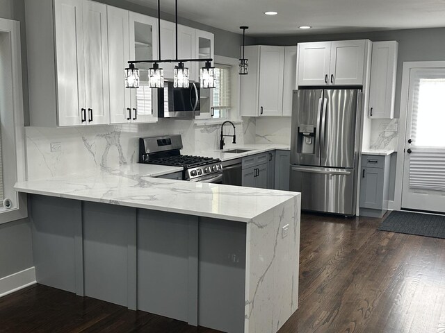 5426 N Bernard St, Chicago, IL 60625 - kitchen with stainless steel appliances, light stone countertops, a peninsula, gray cabinets, and recessed lighting