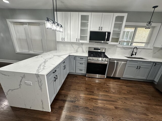5426 N Bernard St, Chicago, IL 60625 - kitchen with appliances with stainless steel finishes, a peninsula, light stone counters, decorative backsplash, and gray cabinets