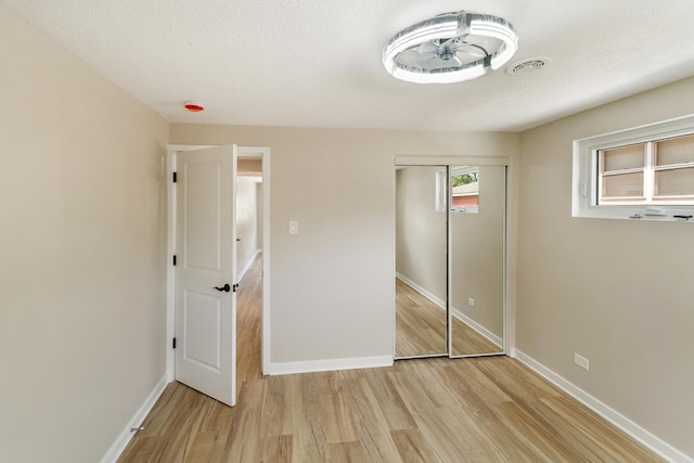 2637 W 93rd Pl, Evergreen Park, IL 60805 - unfurnished bedroom with light wood-style flooring, a closet, and a textured ceiling