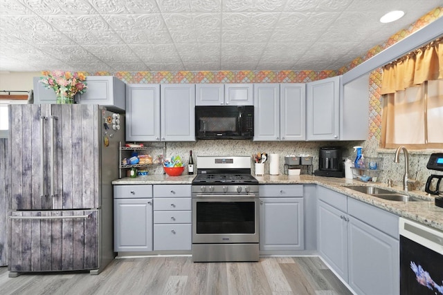 14848 Keystone Ave, Midlothian, IL 60445 - kitchen featuring black microwave, stainless steel gas range, freestanding refrigerator, dishwashing machine, and light wood-style flooring